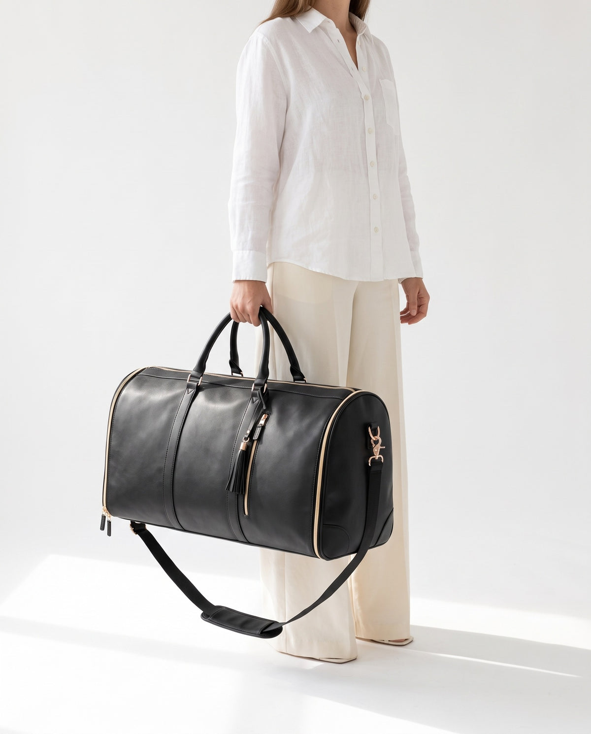 The OneBag in Onyx & Gold — carried for scale.