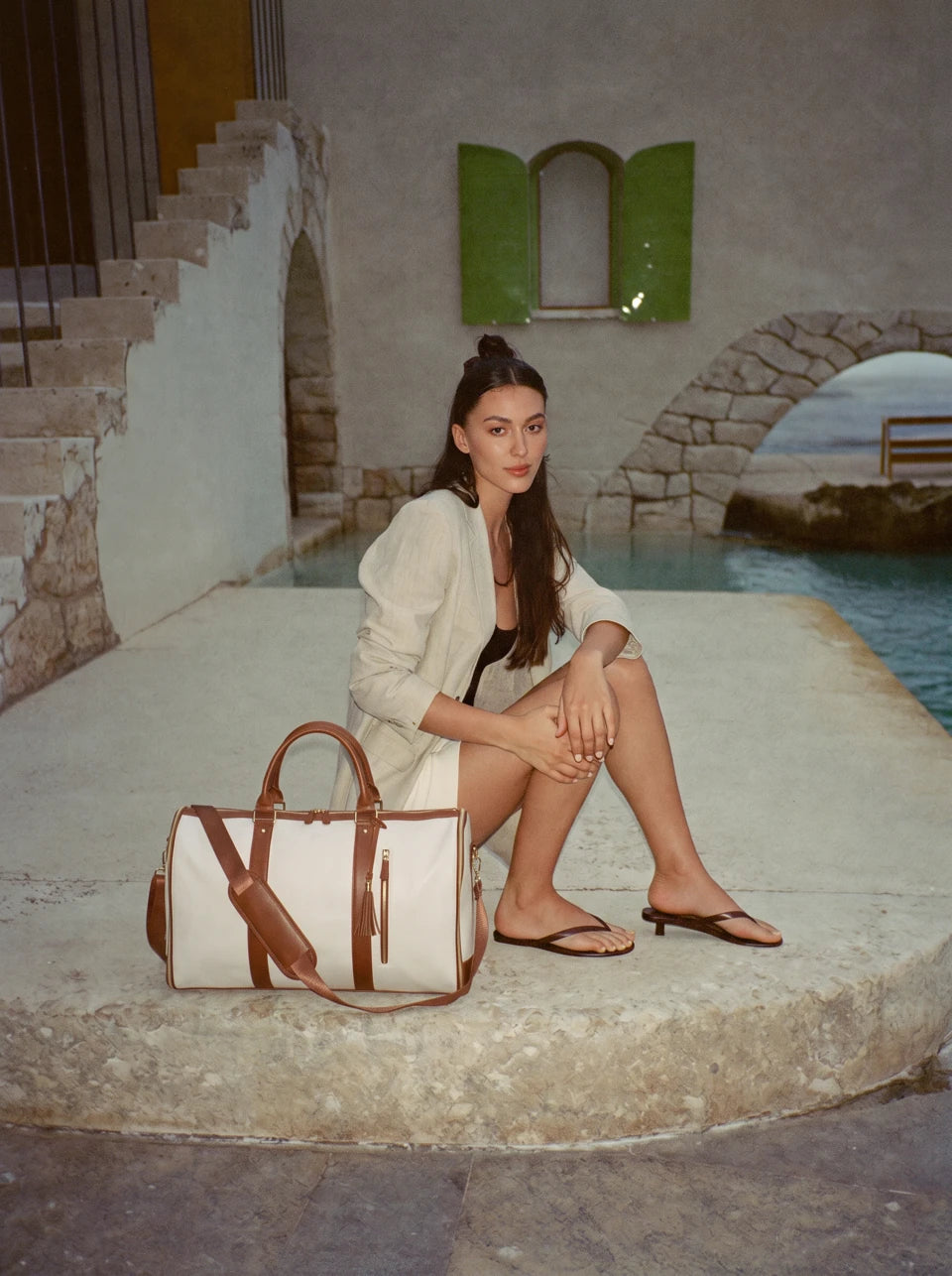 Recent Andelène editorial: a traveller with the Ivory & Cognac bag on the stone steps at Marina Piccola, Capri.